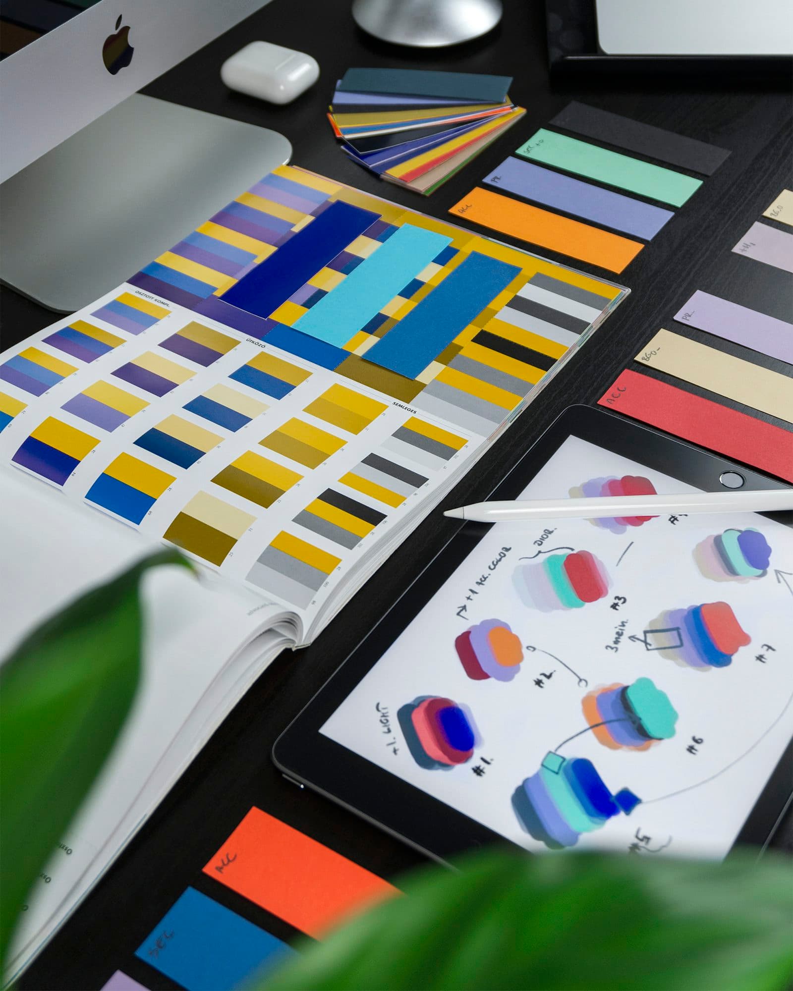 Designer's desk with colour swatches and a brand design system in progress