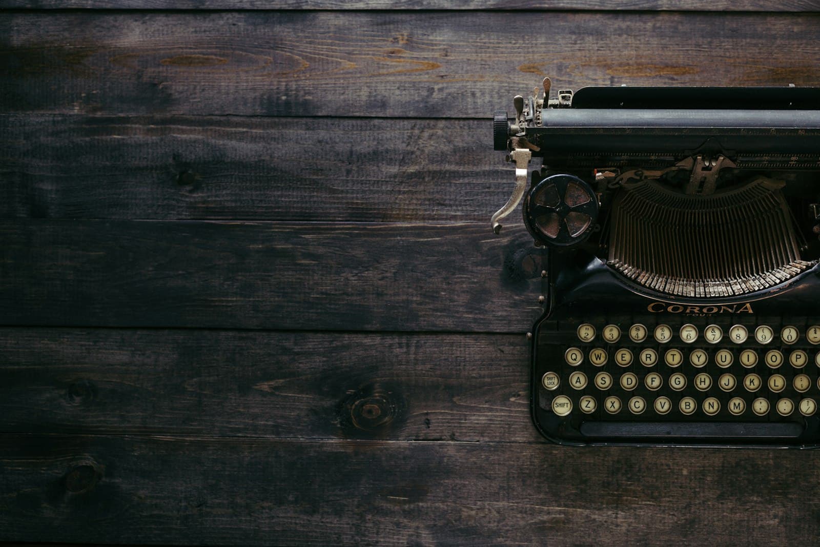 Vintage typewriter on a dark wooden desk, seen from above